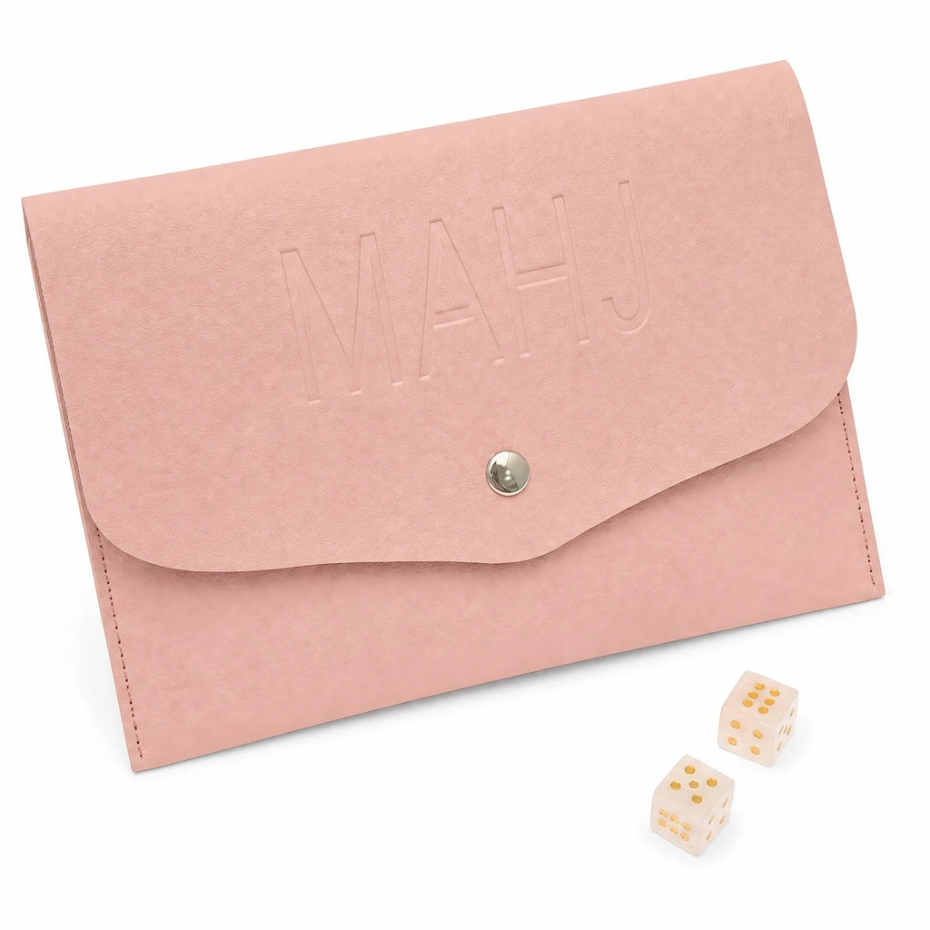 Pink snap pouch with MAHJ on the flap, beside two pink marbled dice