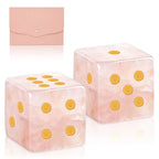 Two pink marbled dice with gold pips in front of their pink pouch