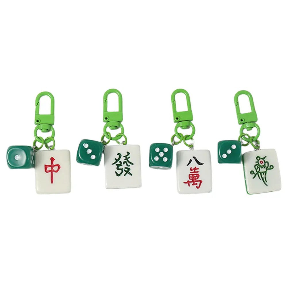 Four mahjong tile charms with green clasps and small green dice