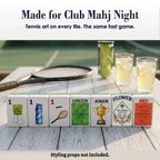Seven Tennis mahjong tiles on a wood table by a racket and iced drinks: 1 Bam, 1 Dot, 1 Crak, GREEN, Joker, Flower and RED
