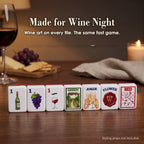 Seven Wine mahjong tiles on a wood table by a glass of red wine: 1 Bam, 1 Dot, 1 Crak, GREEN, Joker, Flower and RED